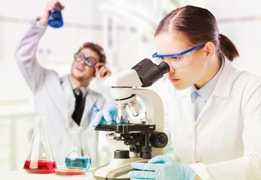 scientist looking through a microscope