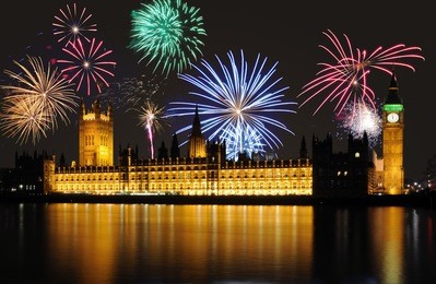 clock shows midnight - fireworks above big ben / parliament, london