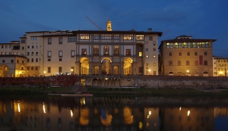 local life along arno river under the uffizi gallery at night, florence, italy