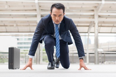 businessman set in start running position prepare to fight in business race.
