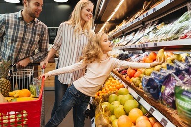 family with shopping cart in supermarket store