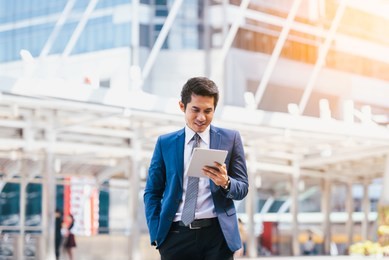 business man using and working on digital tablet with outside office city background . concept businessman lifestyle.