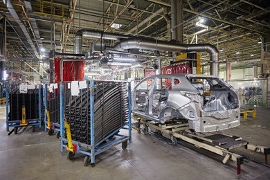 the bodies of cars on the assembly line go on the conveyor at the car factory. modern production. on the shelves are the steel parts