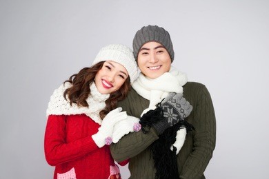 happy pair of male and female having fun wearing warm clothes