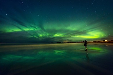 amazing view on the northern lights, beautiful green lights on the sky at night, traveler woman enjoying aurora, merry dancers, beautiful phenomenon in norway