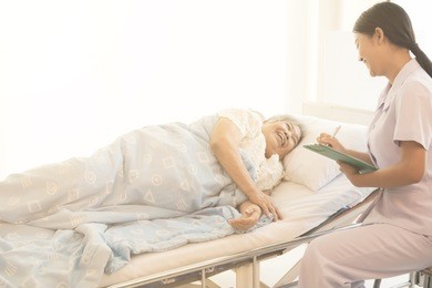 nurse with patient. routine health check and talking. female nurse with senior chinese woman.