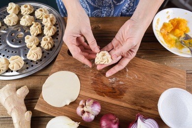 woman cooking. making traditional asian steam dumplings with vegetarian stuffing
