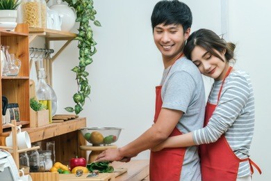 portrait of asian lover or couple hugging and cooking with smiling action in the kitchen room at the modern house, couple and life style concept.