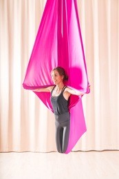 asian woman training in a fitness room with fly yoga elements