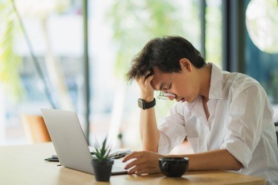 shot of stressed asian business man in the office.