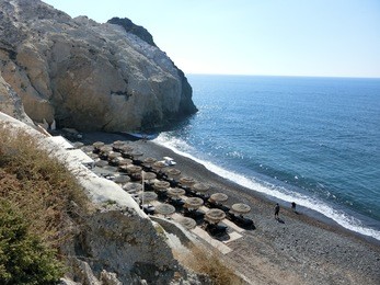 the top view of black beach of kamari, santorini, greece.