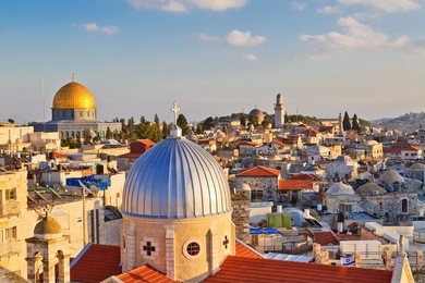 a view on rooftops of old city of jerusalem. grey dome of church of our lady of the spasm (armenian church) and golden dome of the rock.