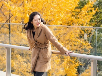 portrait of a beautiful chinese girl stand with golden autumn forest background.