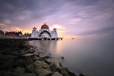 long exposure sunset over malacca straits mosque ( masjid selat melaka) with dramatic sky background. it is a mosque located on the man-made malacca island near malacca town, malaysia