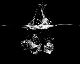 three ice cubes falling into the water with a splash