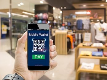 moblie wallet payment with qr code concept.hands holding mobile phone on  blurred clothing shop in department store
as background