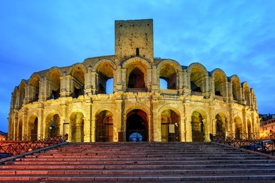 roman amphitheatre in arles, france, illuminated at late evening