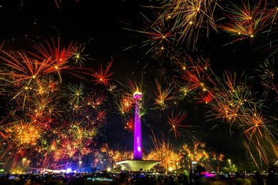 monas monument surrounded by fireworks during new year’s eve celebration