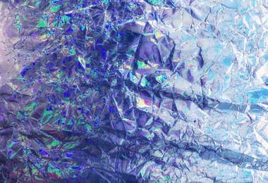 shimmering iridescent holographic wrinkled foil. holographic colorful abstract grunge background. iridescent gradient or mesh holographic foil. template for banner or vibrant sparkly cover print