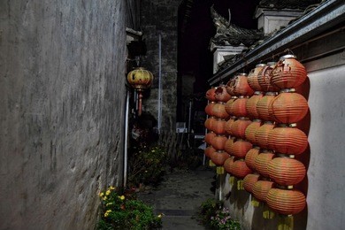 a narrow alley  decorated with red lanterns in xidi, a small ancient village in anhui province in china. 