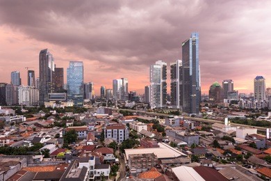 aerial view of the modern jakarta south business district and elevated highway during a dramatic sunset in indonesia capital city and the largest in southeast asia.