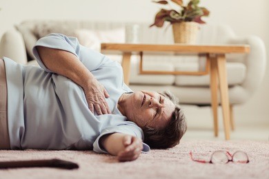 elder woman lying on the floor and having a heart attack at the rest home