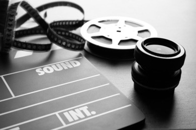movie clapper and lens on grey background, closeup