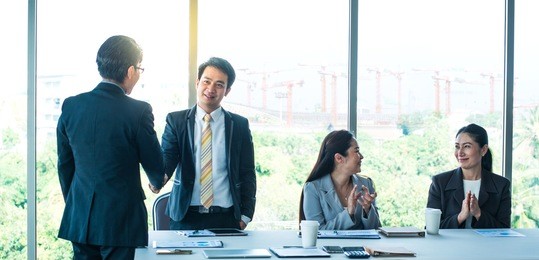 two businessmen shake hands, business deal between asian people  in the black suit