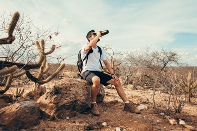 tired hiker drinks water from a bottle