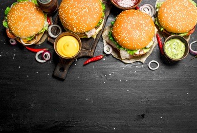 fast food. various burgers with sauces. on the black chalkboard.