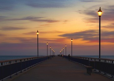 new brighton pier christchurch new zealand dark night morning symmetrical lights people bridge wharf