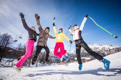 group of friends with ski on winter holidays - skiers having fun on the snow