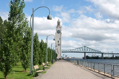 montreal clock tower located at the entrance of the old port of the city. also called victoria pier or sailors memorial clock. in the background jacques cartier bridge.
