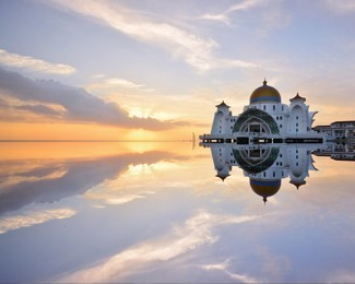 beautiful reflections view of the majestic malacca straits mosque ( masjid selat) during sunset. malacca straits mosque located at malacca city, malaysia.