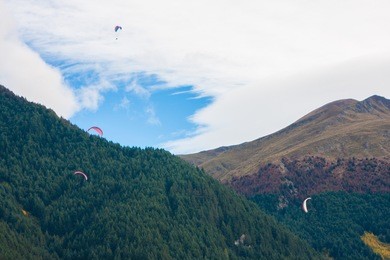 view of big hills with visible paragliders