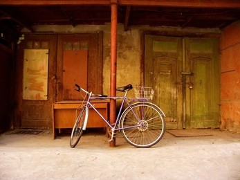 vintage lilac bicycle on the background of old big doors
