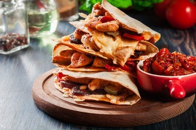 stack of quesadillas with chicken, sausage chorizo and red pepper served with salsa. mexican cuisine. side view