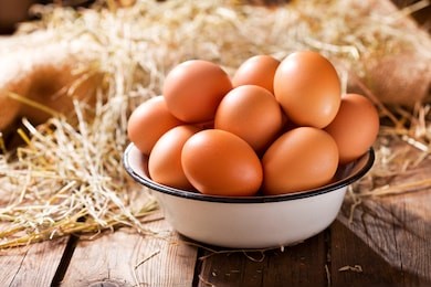 bowl of fresh eggs on wooden background