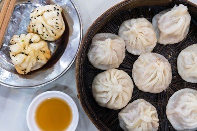 enjoying traditional shanghai food including pan fried dumpling and xiaolongbao