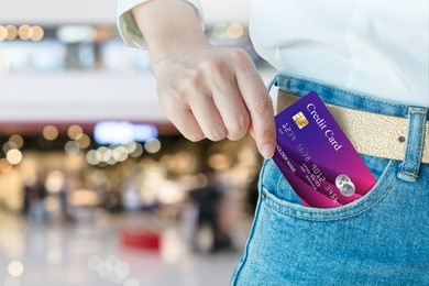 women hand pick up realistic credit card with shopping mall blur background