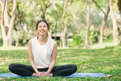 young asian woman yoga outdoors keep calm and meditates while practicing yoga to explore the inner peace. yoga and meditation have good benefits for health. yoga sport and healthy lifestyle concept.
