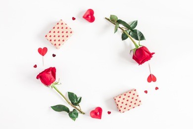 valentine's day. round frame made of rose flowers, gifts, candles, confetti on white background. valentines day background. flat lay, top view, copy space.