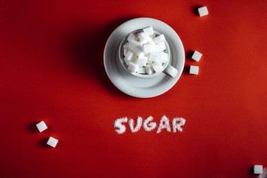 cup with sugar cubes. word from sugar