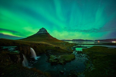 this beautiful northern lights or aurora borealis in iceland was taken at or around kirkjufell mountain and kirkjufellfoss near grundarfjordur during a winter night in november.  