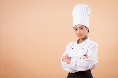 portrait of confident young asian woman chef; confident woman chef; young professional female cooking staff, girl pastry chef, woman cook or female baker; successful asian chef studio isolated