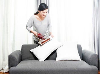 housewives use a vacuum cleaner to clean the dust in the pillow
