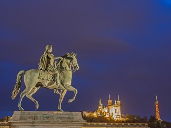 lyon at night with monument "the horse" and church notre-dame de fourviere