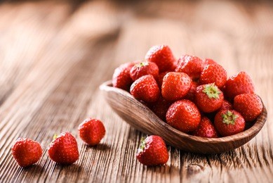 strawberries in wooden bowl. fresh nice strawberries on wooden table. juice strawberry