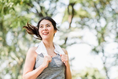 beautiful young healthy asian woman running in the park in the morning