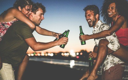 happy friends drinking beer and having fun on the beach after sunset - young people enjoying summer vacation - youth ,holidays, party and friendship concept - soft focus on right man face